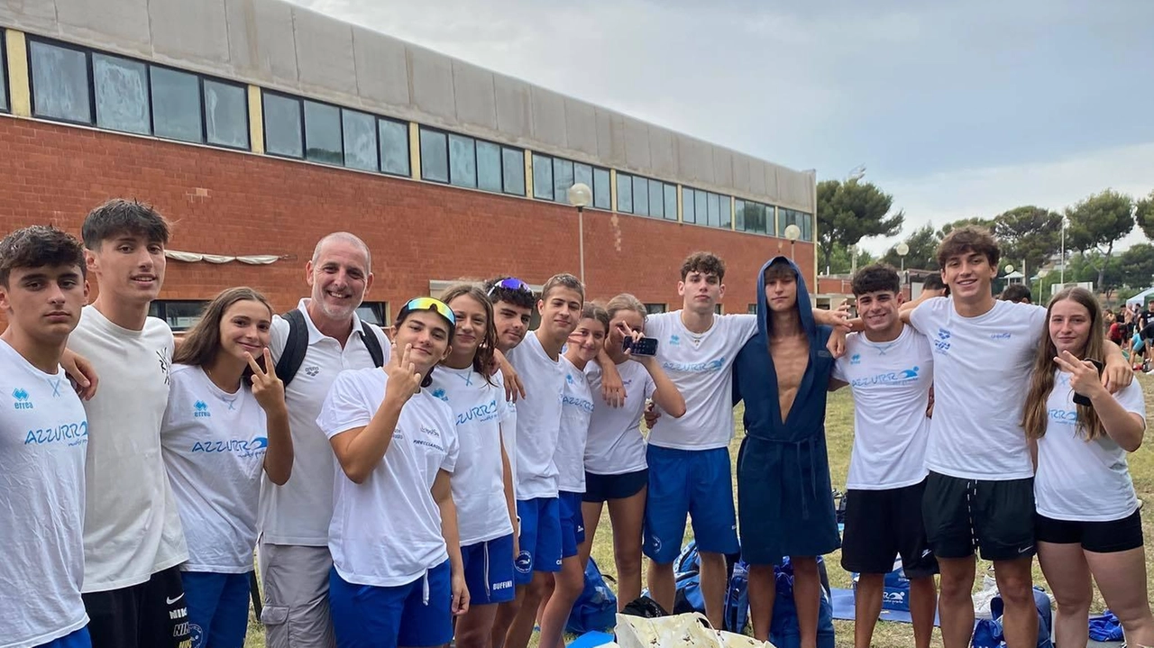 Il tecnico Marco Lilli insieme ad alcune nuotatrici ed alcuni nuotatori dell’Azzurra al Trofeo città di Calenzano