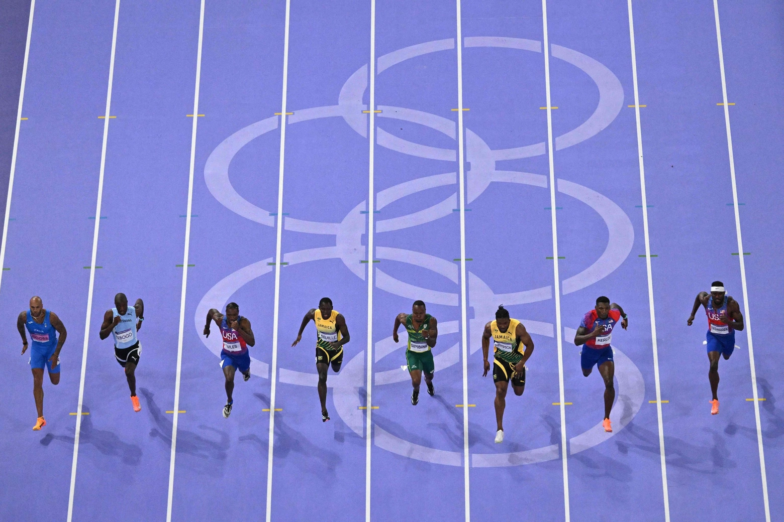 Jacobs (primo da sinistra) e i finalisti dei 100 metri in azione (Ansa)